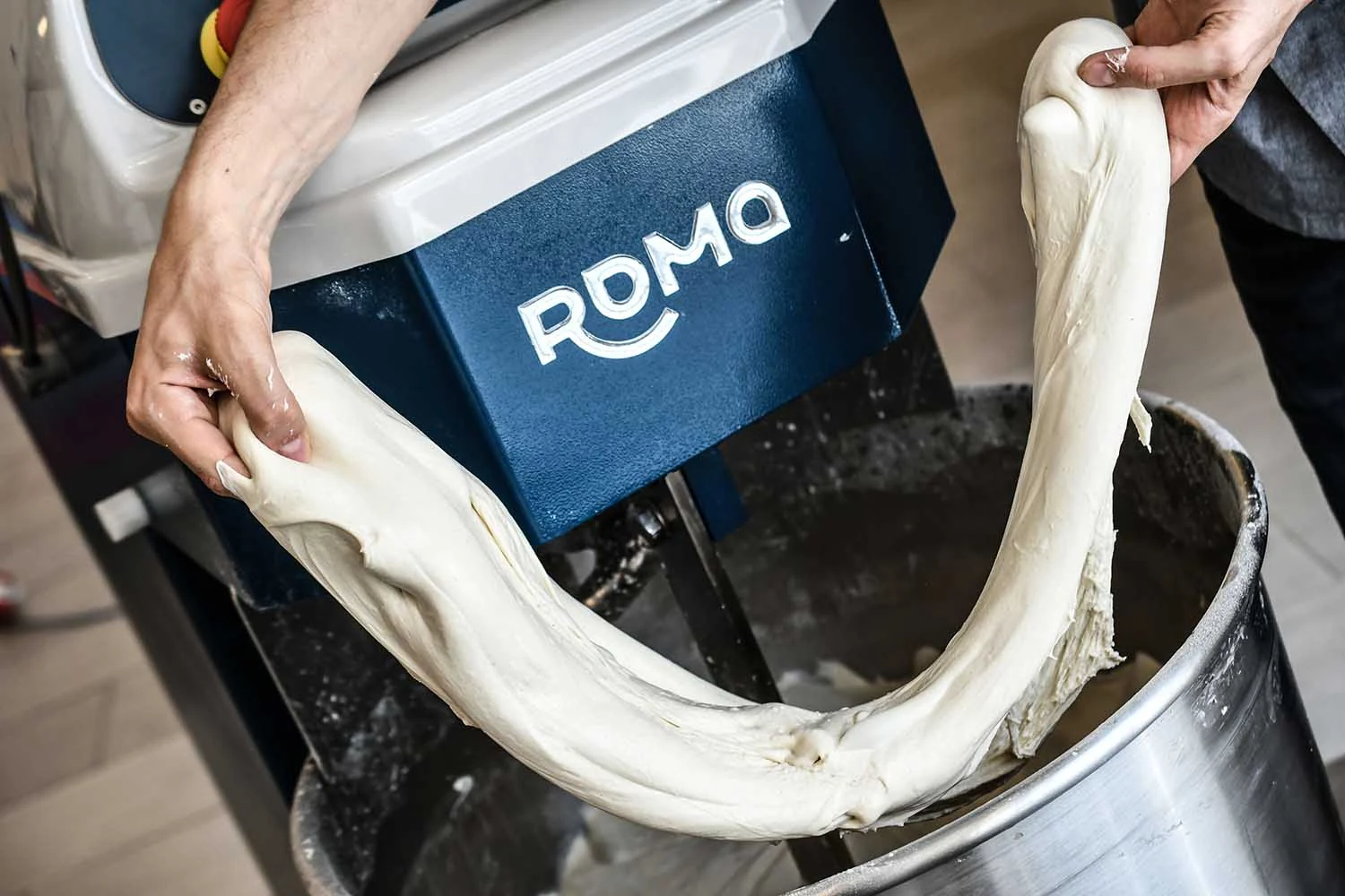 Teig wird von Hand über dem Roma Kessel gedehnt