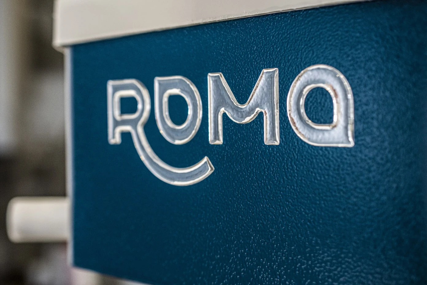 Gros plan sur le logo Roma sur le châssis bleu de la machine